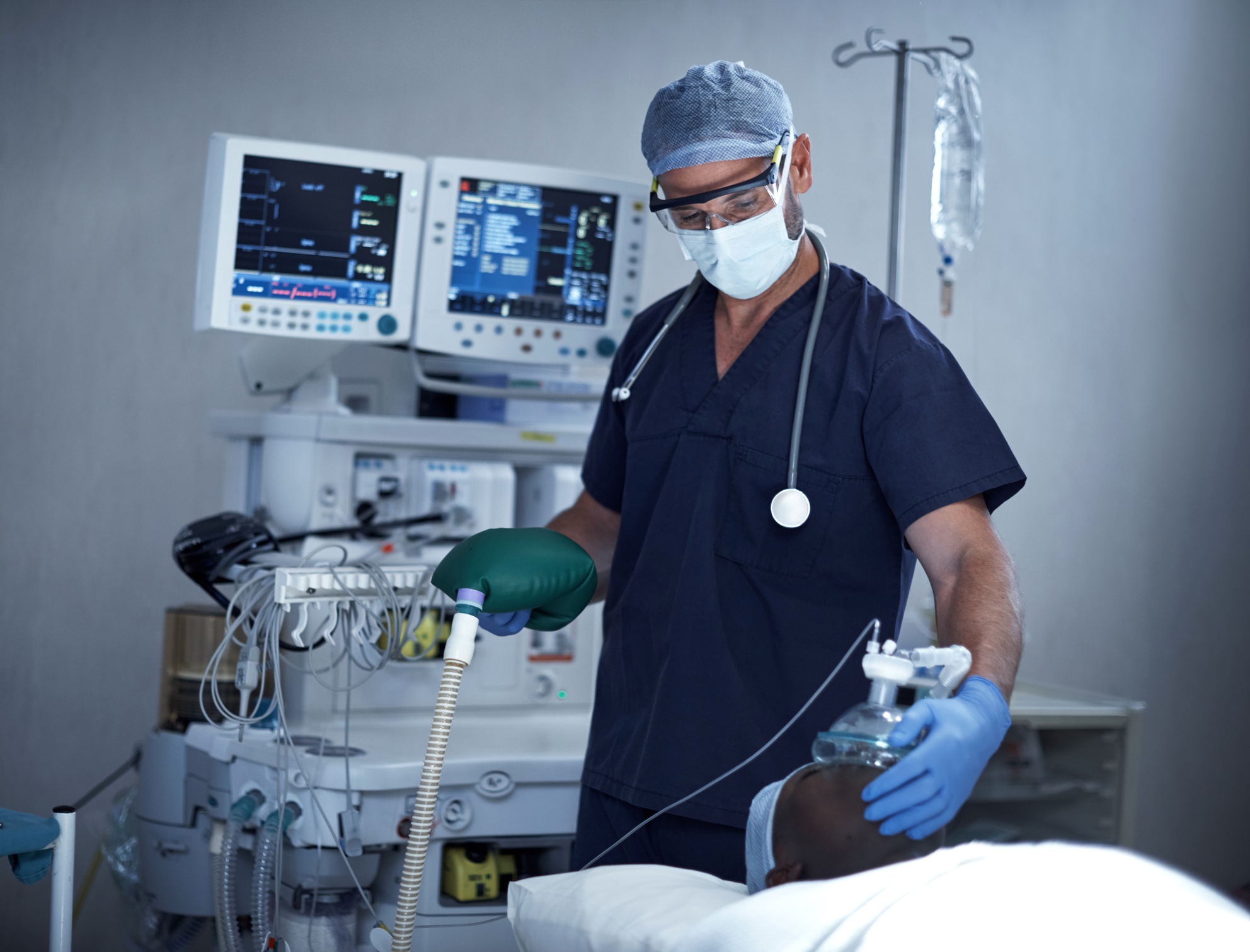 Anesthesiologist utilizing anesthesia cart on patient.