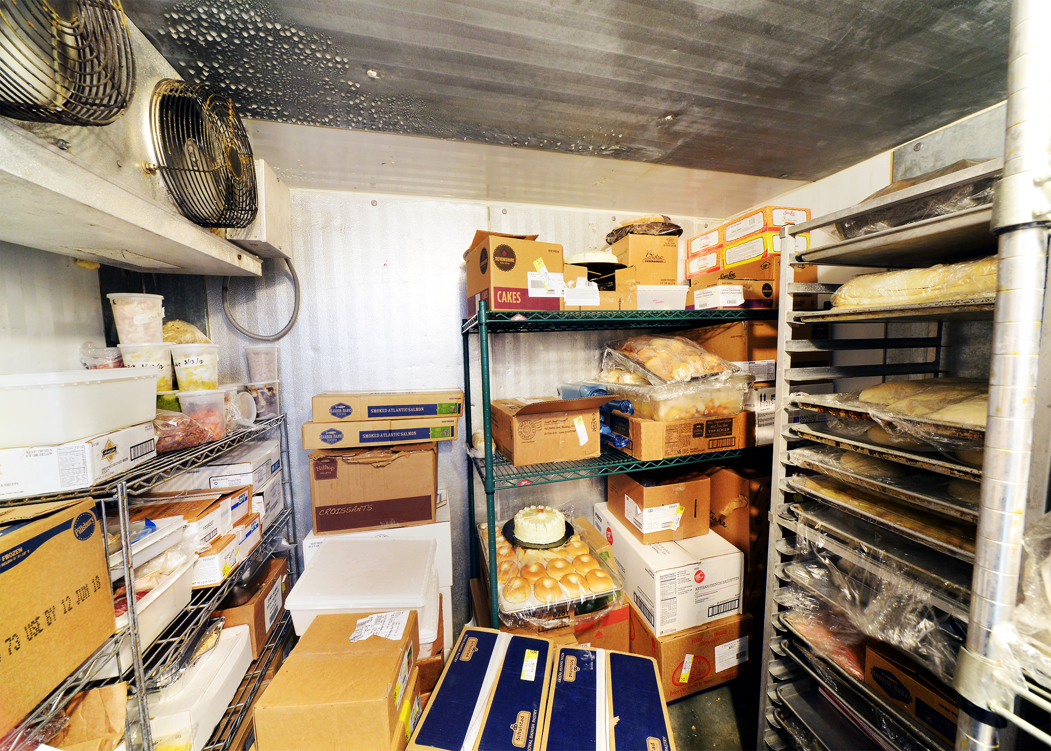 A pantry containing cardboard boxes and a drying rack.