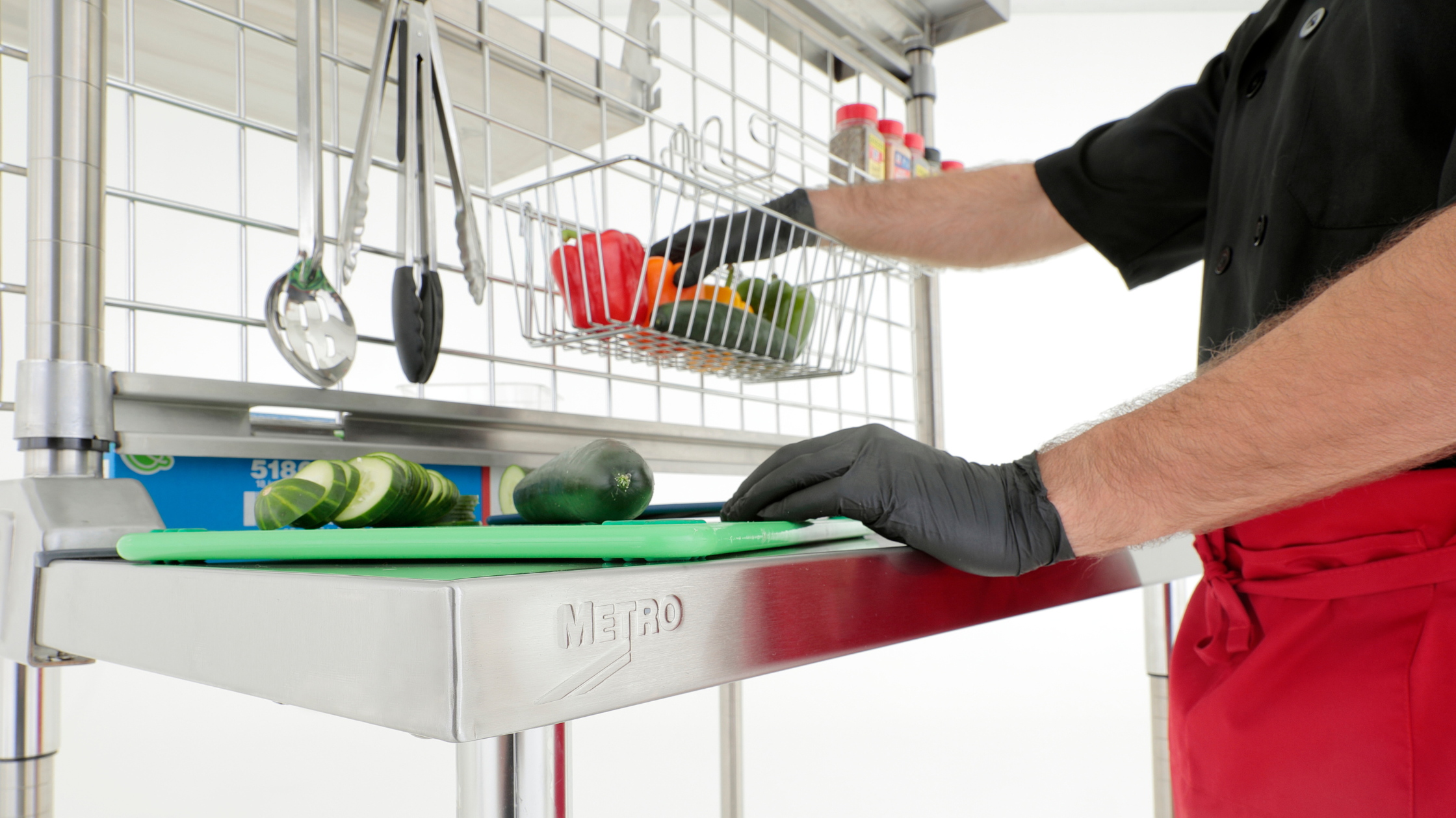 a food service worker prepping vegetables on a Metro TableWorx stainless steel prep table
